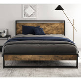 A modern bed featuring a wooden frame supported by sleek metal legs.